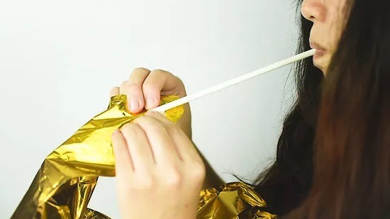 انتهای نی را باد کنید تا بادکنک پر از هوا شود.